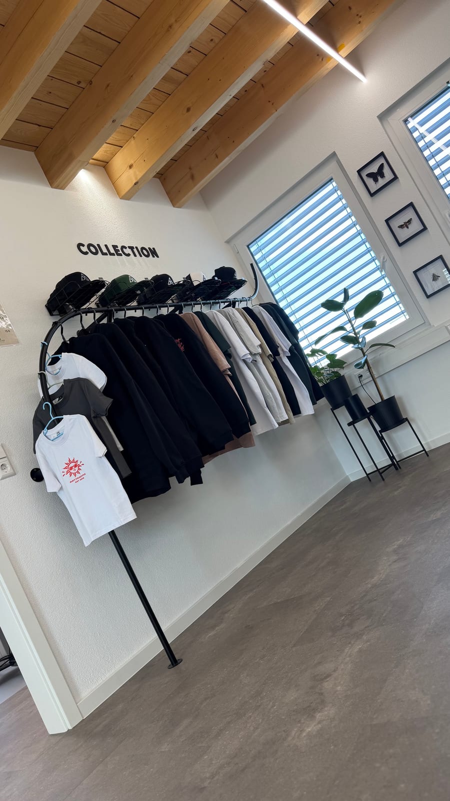 Kleiderstange mit Shirts, Hoodies und Caps der Arttractive Collection